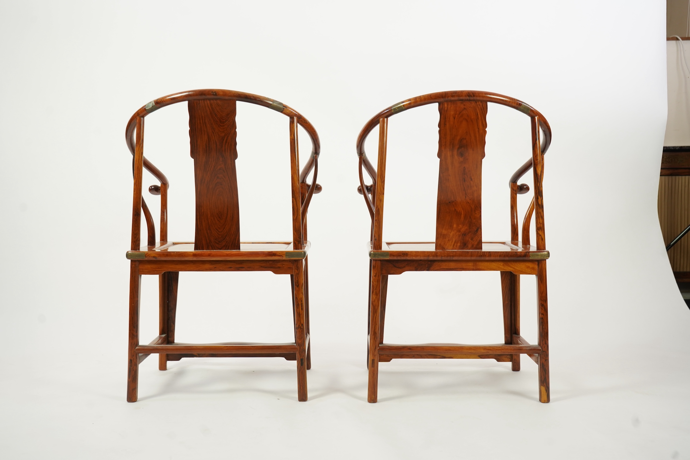 A pair of Chinese huanghuali and brass mounted horseshoe-back armchairs, quanyi, 19th century
